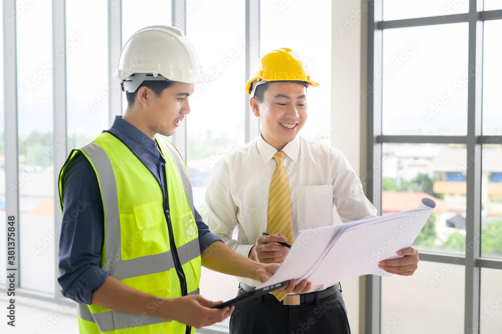 Engineering people are analytics construction plans with blueprint in office Engineering people are analytics construction plans with blueprint in office