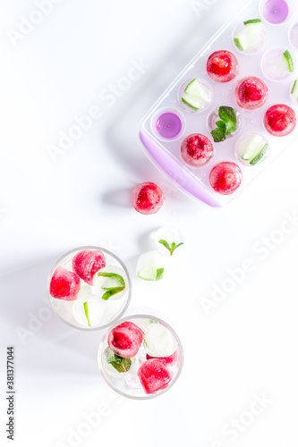 Raspberry and lime in ice cubes top view flat lay