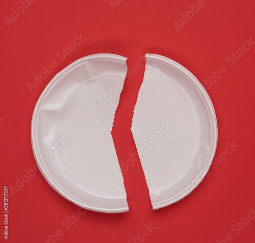 disposable white plastic plate on a red background,