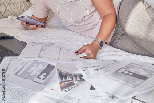 Woman interior designer with interior plans for a new project and notebook
