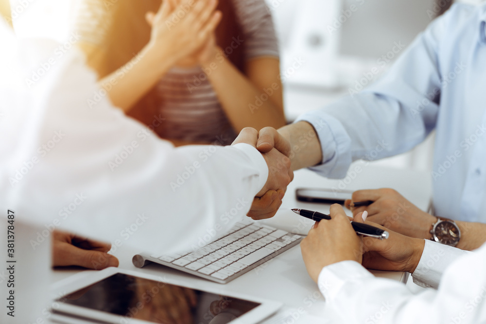 Two businessmen shaking hands in sunny office, close-up. Colleagues applauding of success meeting end Two businessmen shaking hands in sunny office, close-up. Colleagues applauding of success meeting end