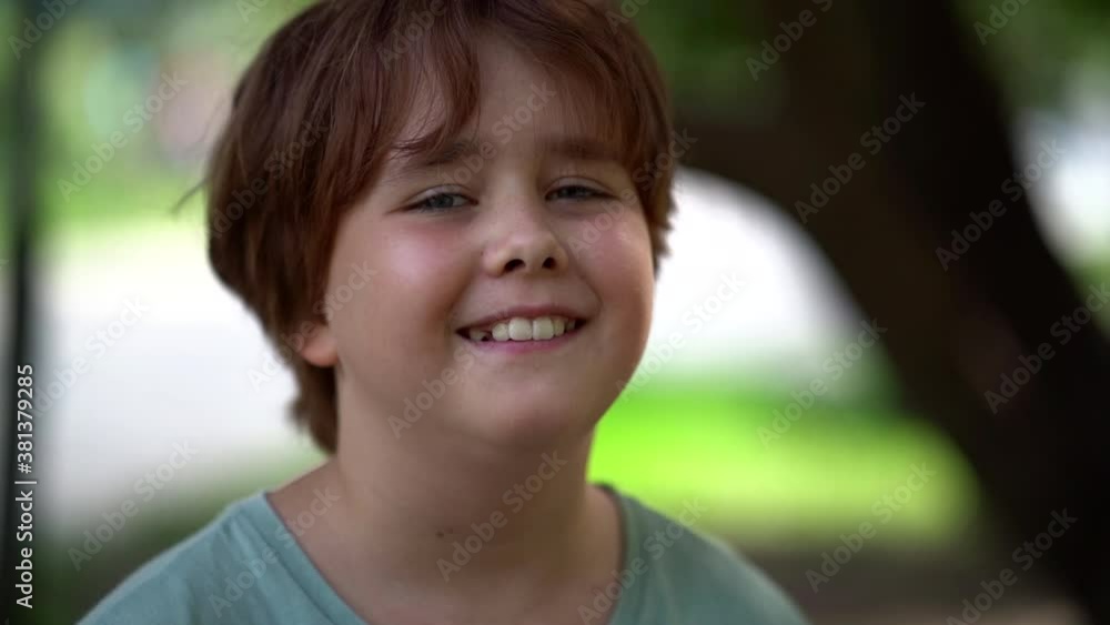 cute smiling little girl is looking at camera outdoors, cheerful funny face of child cute smiling little girl is looking at camera outdoors, cheerful funny face of child