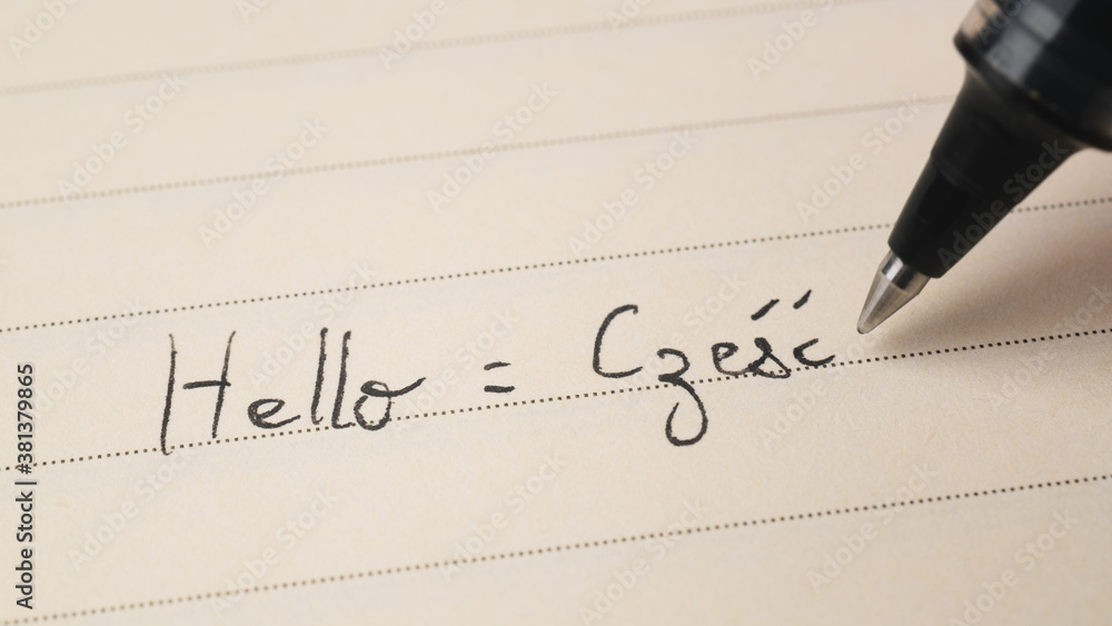 Beginner Polish language learner writing Hello word Czesc for homework on a notebook - obrazy, fototapety, plakaty 