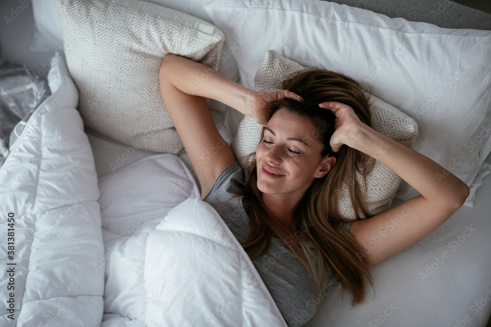 Fototapeta premium Young beautiful woman enjoying in morning.. Girl lying on bed..