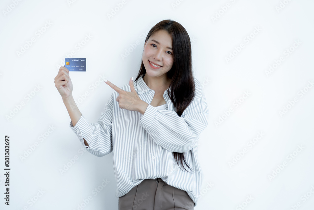 Portrait of a lovely young Asian beautiful woman with long hair holding a blue credit card, her eyes sparklingly at the camera. Ready to pay shopping according to discounted products Portrait of a lovely young Asian beautiful woman with long hair holding a blue credit card, her eyes sparklingly at the camera. Ready to pay shopping according to discounted products