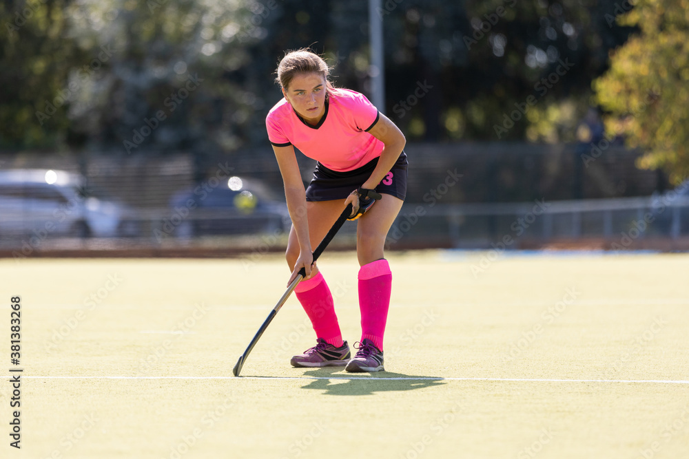 Young female field hockey player on the pitch Young female field hockey player on the pitch