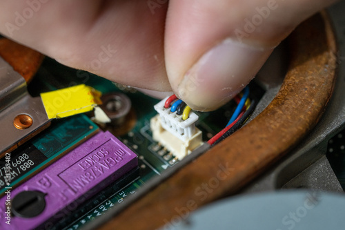 Close-up photo of an electrician repairing the computer's circuit