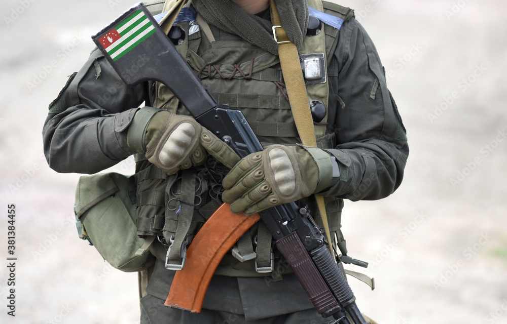 Flag of Republic of Abkhazia on submachine gun butt. Military, army, armed forces, soldiers. Collage. Flag of Republic of Abkhazia on submachine gun butt. Military, army, armed forces, soldiers. Collage.