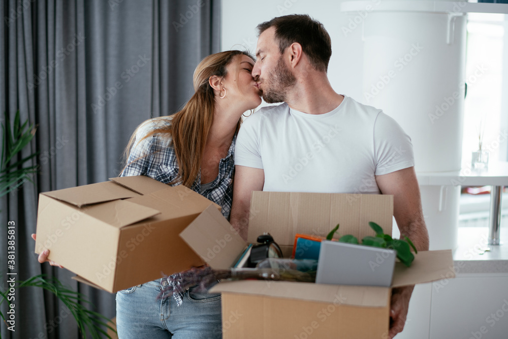 Husband and wife are moving into the apartment. Happy couple is unpacking their belongings Husband and wife are moving into the apartment. Happy couple is unpacking their belongings