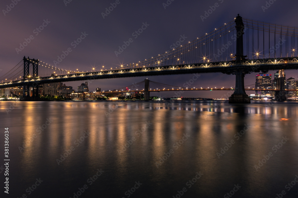 View of Manhattan bridge and Brooklyn Bridge from east river with long exposure at dawn