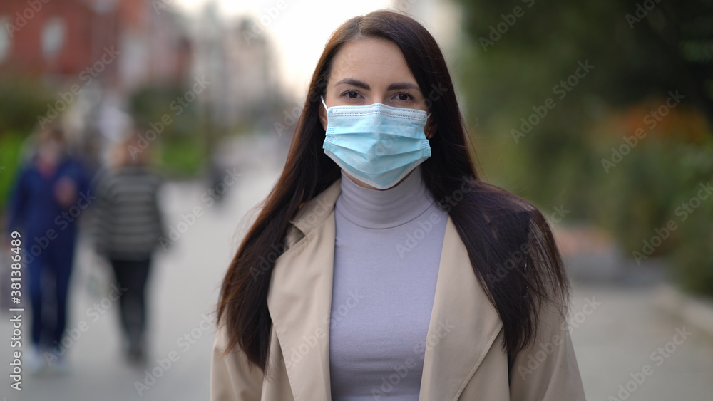 Portrait of a mixed race woman in the city streets during the day, wearing a face mask against the second wave quarantine coronavirus COVID-19 pandemic. Portrait of a mixed race woman in the city streets during the day, wearing a face mask against the second wave quarantine coronavirus COVID-19 pandemic.