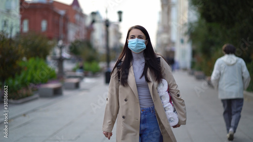 women walking in medical mask with toilet paper during the second wave quarantine coronavirus COVID-19 pandemic.