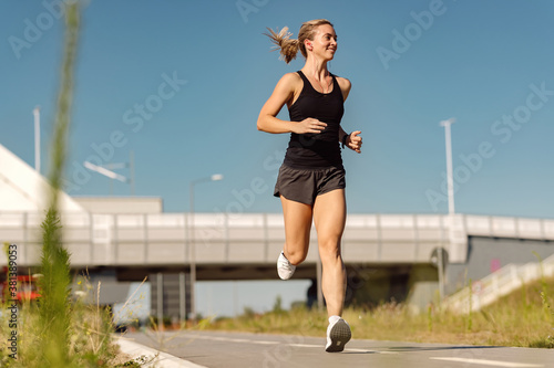 Below view of female runner jogging outdoors. © Drazen
