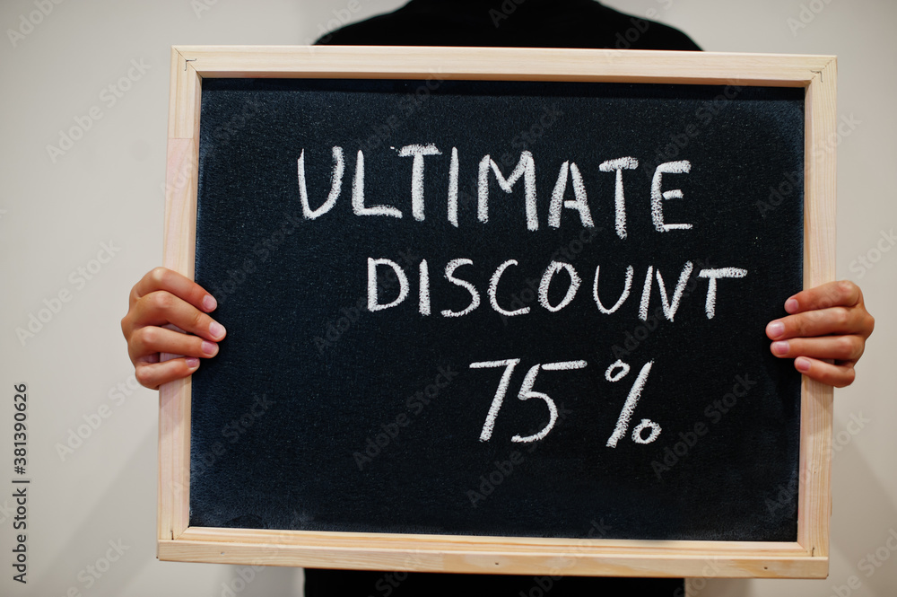 Ultimate discount 75% written on blackboard. Black friday concept. Boy hold board. Ultimate discount 75% written on blackboard. Black friday concept. Boy hold board.