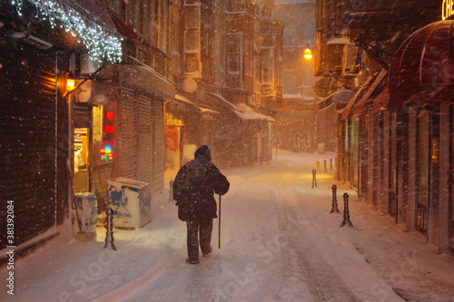 Night street, snow, blizzard, man with a stick. Istanbul