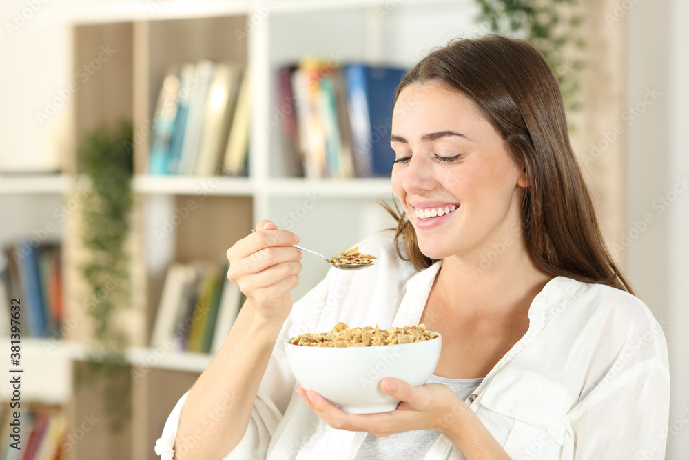 Happy woman eating cereals for breakfast at home Happy woman eating cereals for breakfast at home