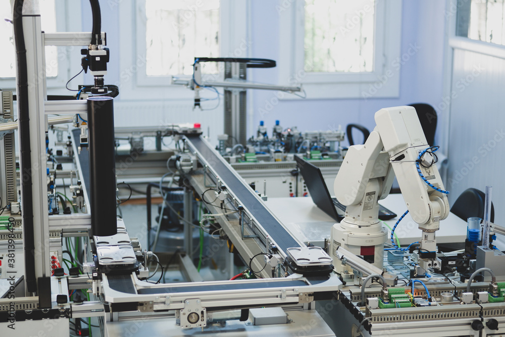 Industry 4.0 concept; artificial intelligence in smart factory prototype. The robot picks up the product from an automated car on the production line. Focus on the robotic arm's gripper. Industry 4.0 concept; artificial intelligence in smart factory prototype. The robot picks up the product from an automated car on the production line. Focus on the robotic arm's gripper.