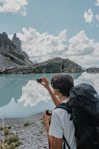 Wanderer am Fotografieren an einem Bergsee auf dem Pizol in der Schweiz
