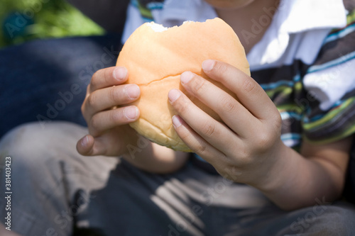ハンバーガーを持つ子供の手