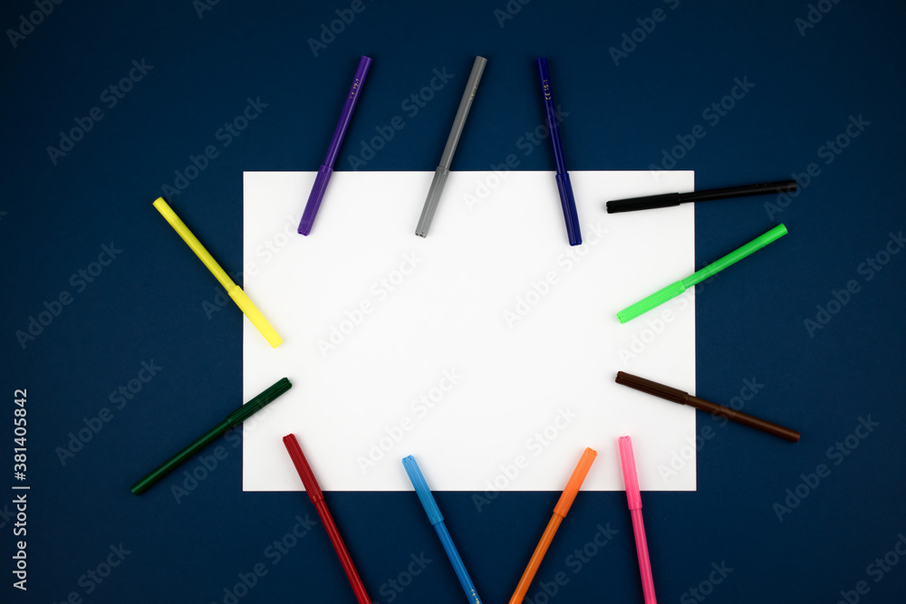 White sheet on a blue table with multicolored markers. Drawing, fine art. Copyspace.
White sheet on a blue table with multicolored markers. Drawing, fine art. Copyspace.