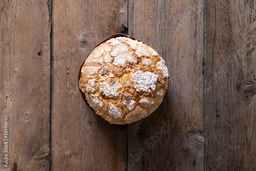Homemade panettone accompanied by biscuits on a wooden table. Delicious Christmas cake. 