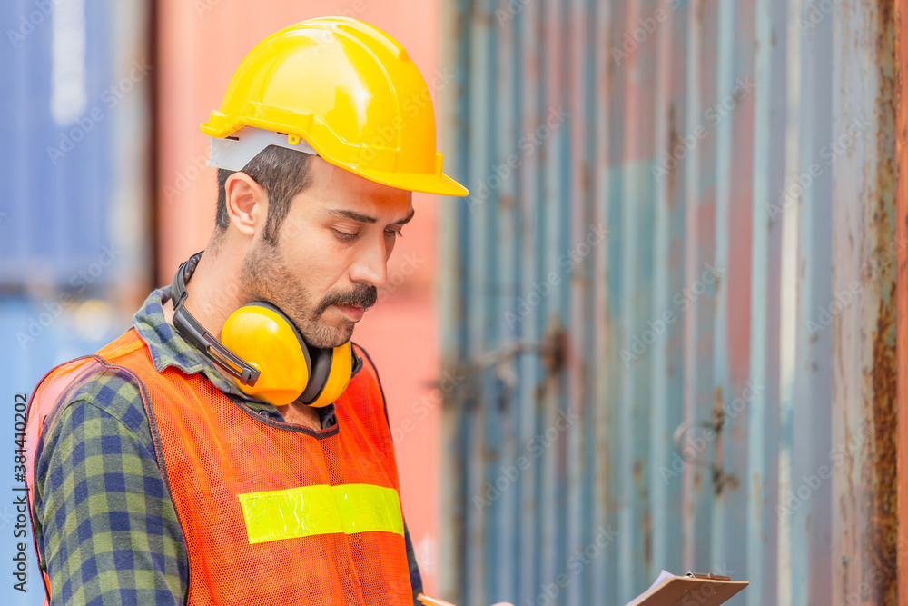 Portrait of factory worker man in hard hat and safety vest, Engineer man with containers box background at cargo Portrait of factory worker man in hard hat and safety vest, Engineer man with containers box background at cargo