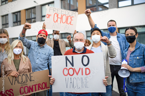 People with placards and posters on public demonstration, no covid vaccine concept. photo