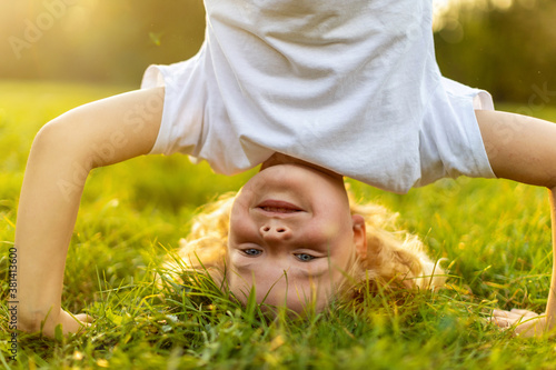 Fotografie Child doing headstand in park