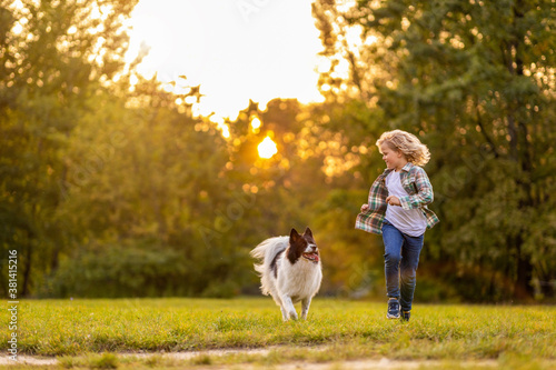 Photography Little boy playing with his dog outdoors in the park