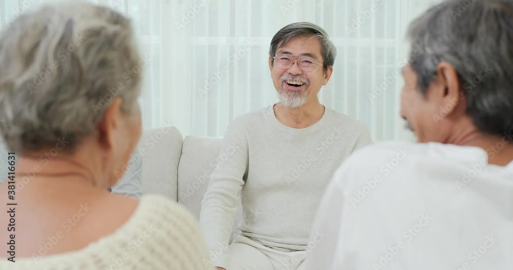 Happy emotion concept. Senior people laughing together at living room. Senior man talking funny story to his friend at home. Retirement activity or lifestyle concept.