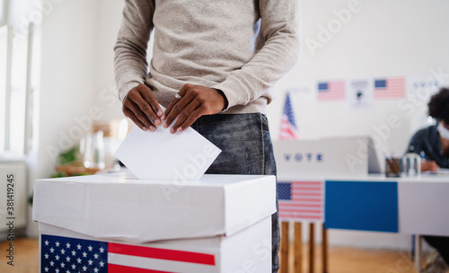Valokuva Unrecognizable african-american man putting his vote in the ballot box, usa elections and coronavirus