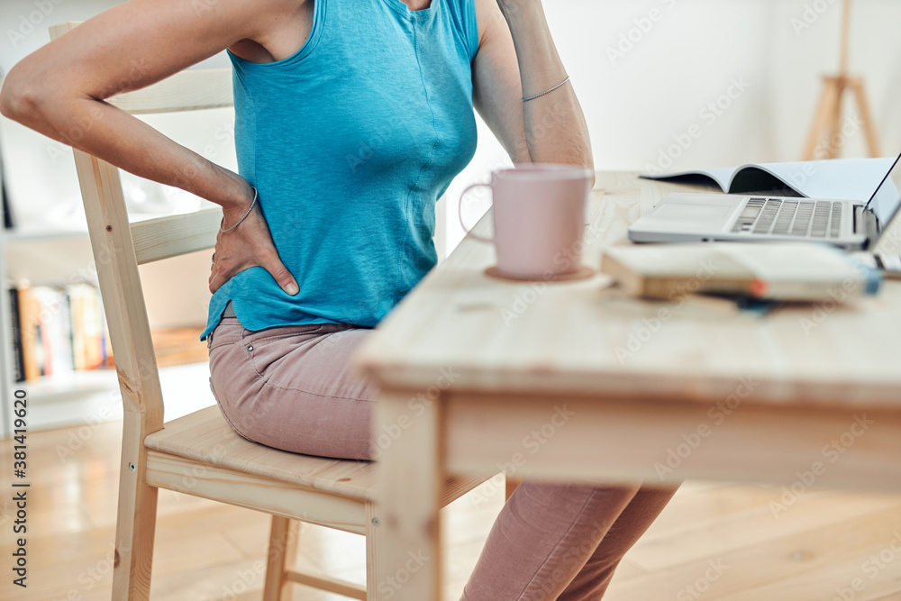 Woman working from home and being depressed, tired with headache and back pain. Modern concept and problems with freelancers. Woman working from home and being depressed, tired with headache and back pain. Modern concept and problems with freelancers.