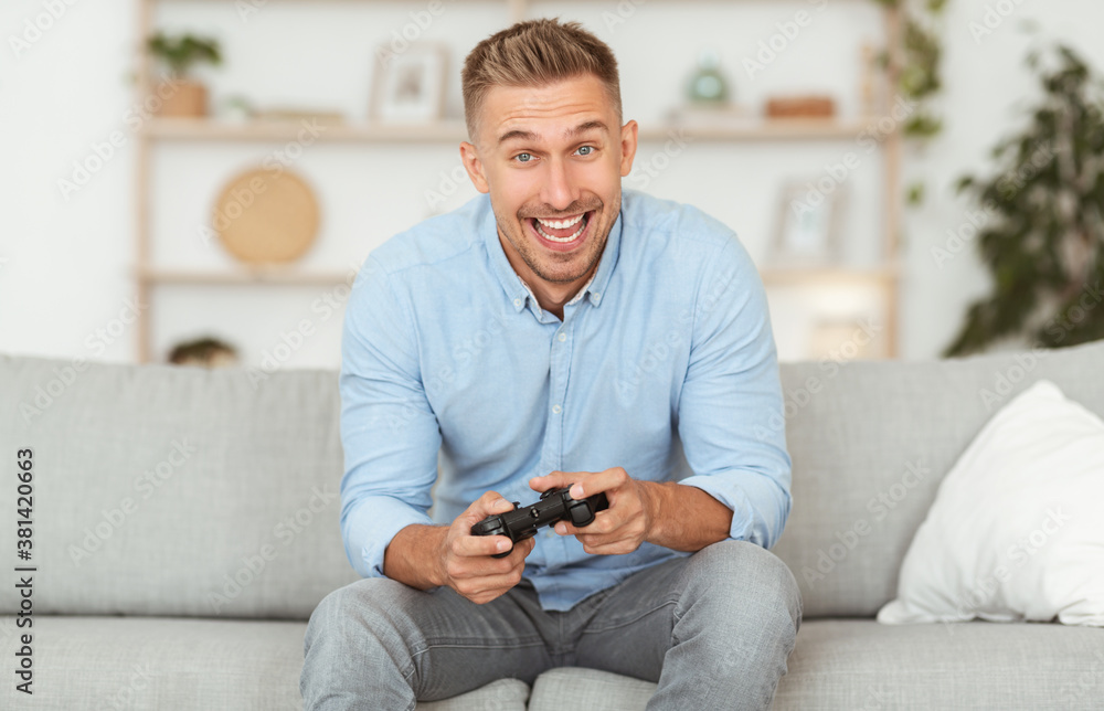 Young guy sitting on couch playing video games