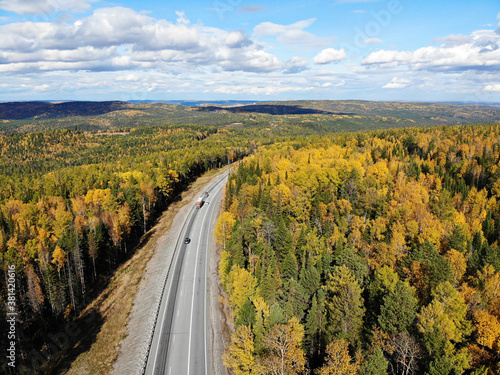 Road through autumn forest in Siberia from the air.