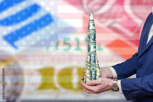 Money rocket in the hands of a businessman against the background of the American flag and currency