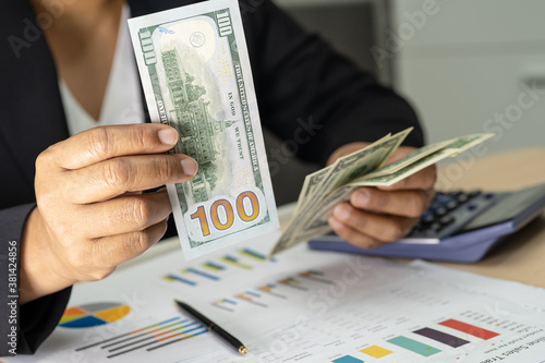 Asian accountant holding Euro banknotes, working, calculate and analyzing report project accounting with calculator and graph report in modern office, finance and business concept.