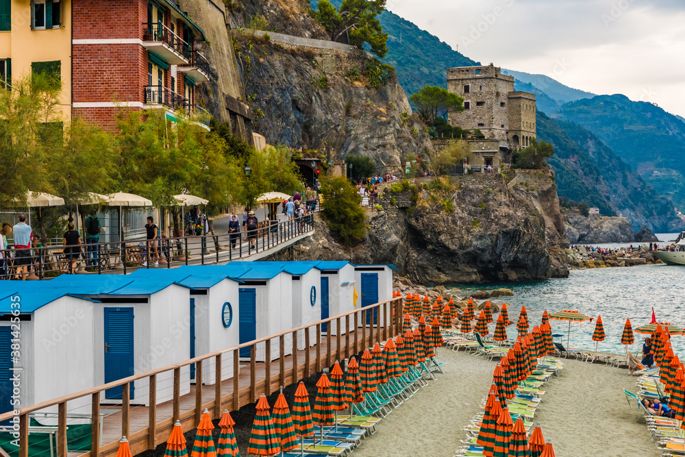 Close-up view of beach and promenade in Fegina, the modern part of Monterosso al Mare in the Cinque Terre area. The connection tunnel to the old town and fortification tower Torre Aurora can be seen.