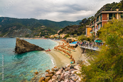 Gorgeous panoramic view of the hillside, the sand beach and promenade with the famous Scoglio di Monterosso rock in Fegina, the modern part of Monterosso al Mare in the Cinque Terre coastal area. photo