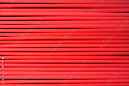 Top view of red  plastic drinking straws in a row. 