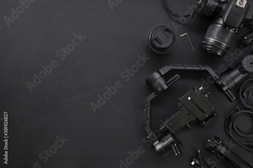 top view of work space photographer with digital camera and accessory on black background with copy space. flat lay photo