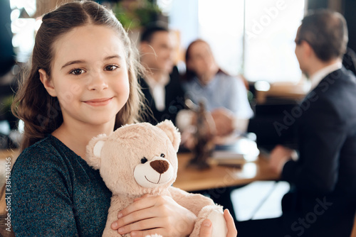 Beautiful girl with parents stands in the office.