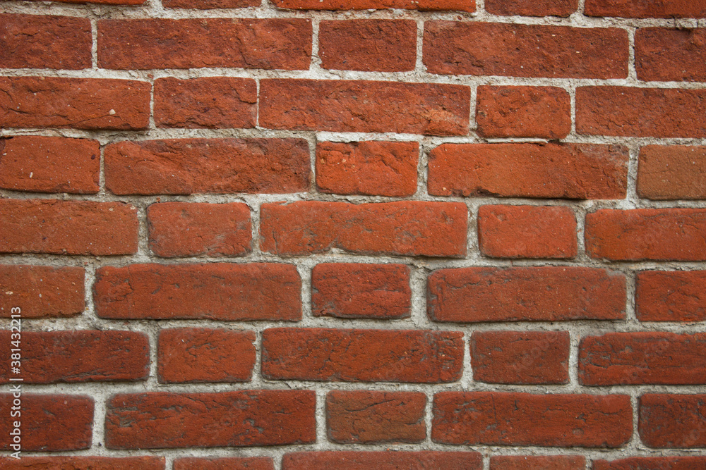 The wall is made of old red brick with white seams.