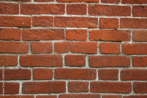 The wall is made of old red brick with white seams.