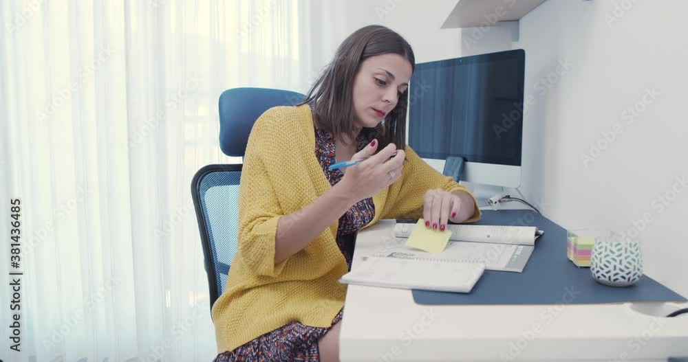 Profesora estudiando y  tomando notas preparando sus clases en casa debido a la pandemia. 