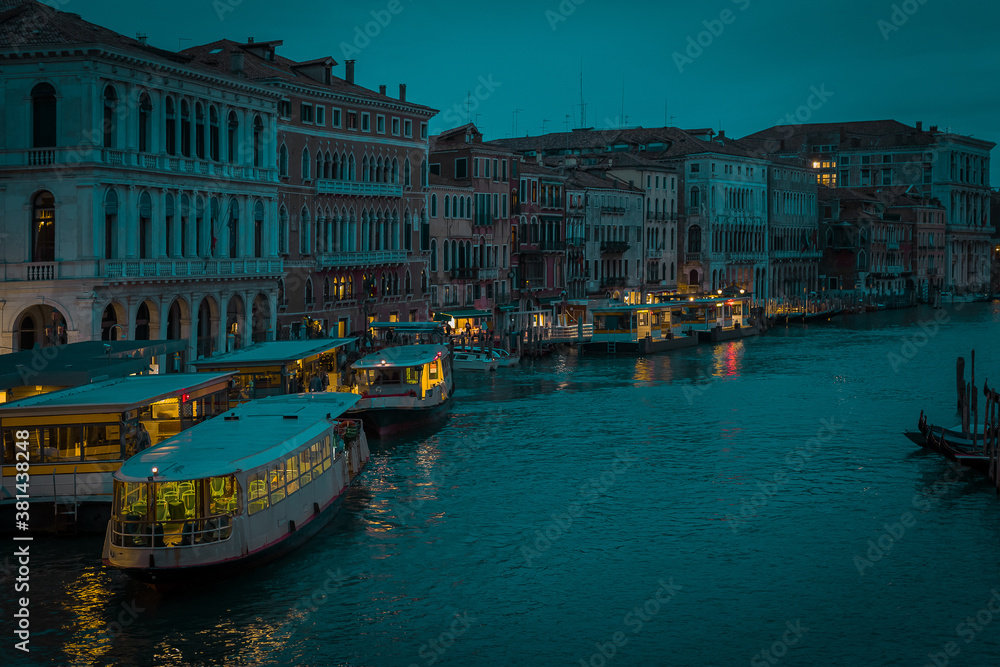Enchanting venice in night time or evening light during blue hour. Canal in venice with no traffic, calm during a rainy season with not much tourists due to Coronavirus or Covid.