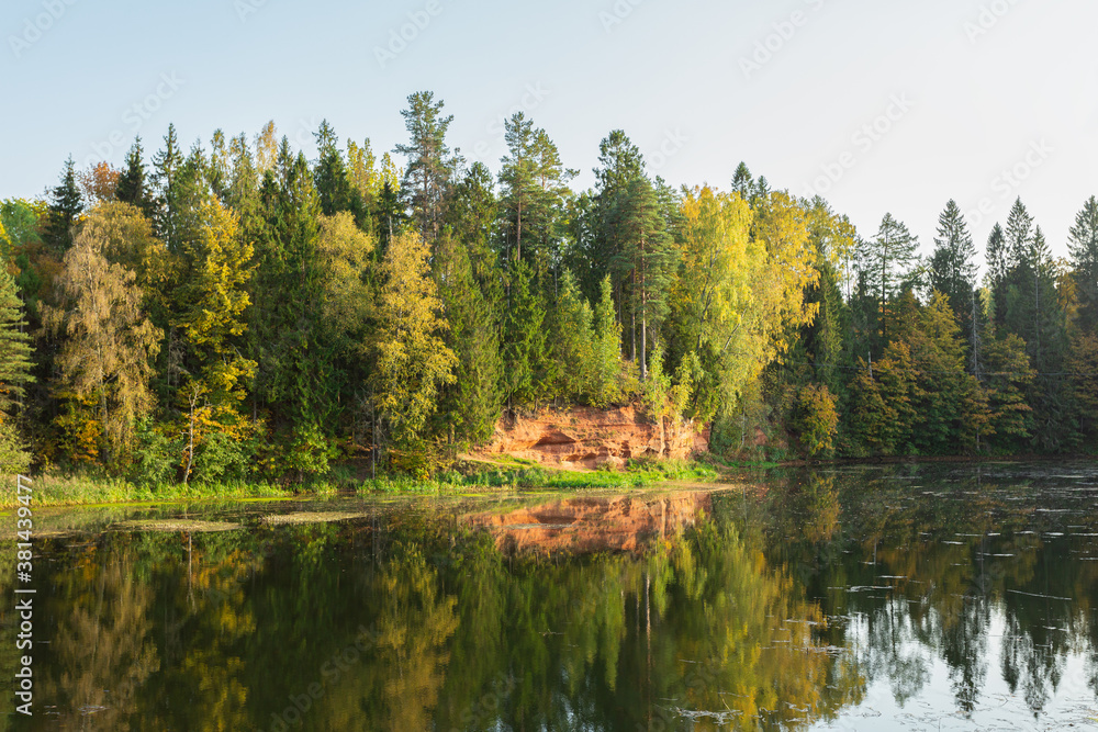 Picturesque lake and a sand quarry in the autumn forest in Rozhdestveno, Saint Petersburg, Russia. Horizontal image.