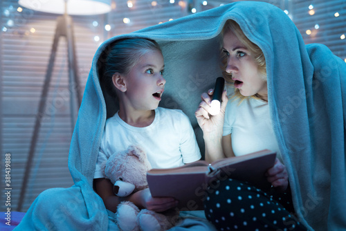 Grandmother and granddaughter are reading book. photo