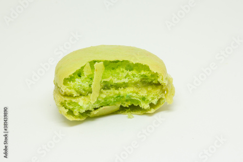 Macaroons isolated on white background. French Color Pastel Macarons. macarons cakes. Small French cakes. Sweet and green french macaroons. bitten macarons, berry and vanilla taste.