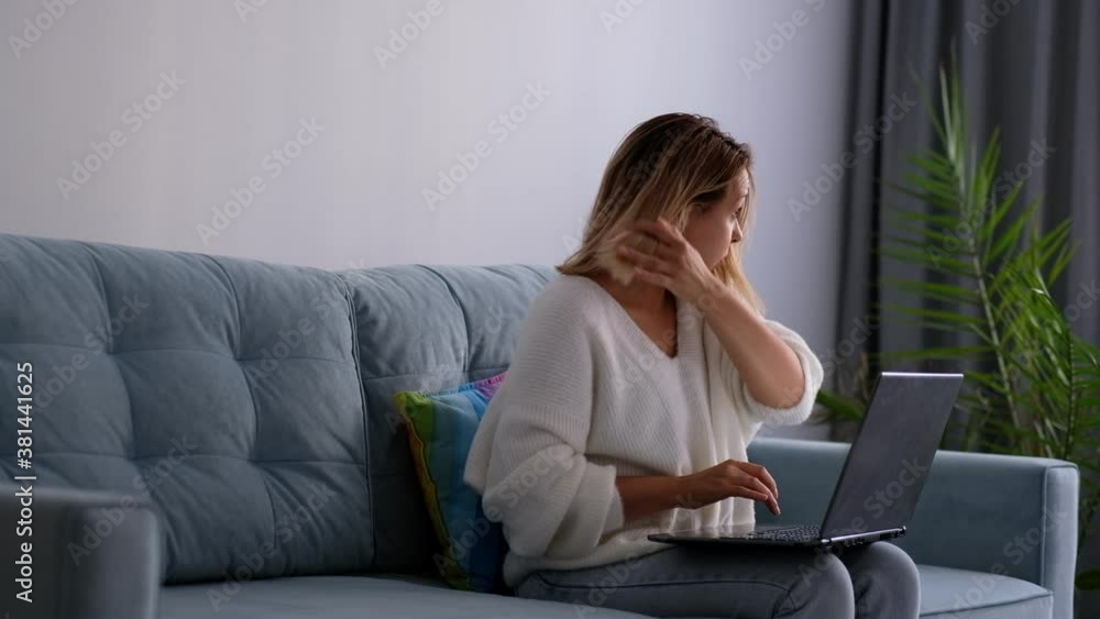 lateral pan shot of young attractive and bored latin woman on her 30s working at home living room sitting on couch with laptop computer lateral pan shot of young attractive and bored latin woman on her 30s working at home living room sitting on couch with laptop computer