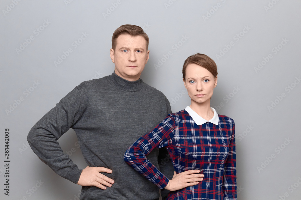 Portrait of serious man and woman standing next to each other Portrait of serious man and woman standing next to each other